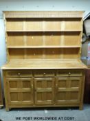 A light oak dresser in the Arts and Crafts style (H180 x W146 x D46cm)