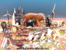 A collection of largely African carved animals together with horn birds and a Tibetan wall frieze