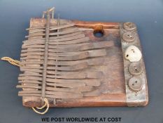 African tribal Lamellophone or Kalimba (thumb piano) with 19 bent metal notes and five bottle tops