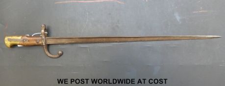 A c1877 French bayonet with the narrow 'T' form blade, wood grips and brass pommel.