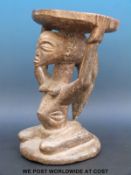An African tribal stool with a kneeling female figure supporting the seat on her head (35cm tall)