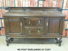 An oak sideboard with cupboards flanking two drawers (W152 x H110 x D31cm)