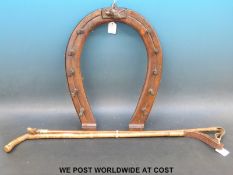 A mahogany whip rack in the form of a horseshoe with fox head carving,