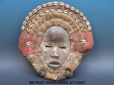 An African tribal Dan mask with shells and hessian surround (length 34cm)
