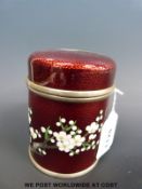 A Japanese ginbari white metal tea caddy with bird and prunus decoration on a red ground (10.