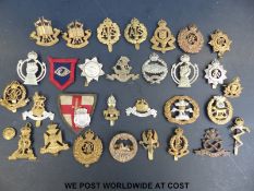 A quantity of mainly WWII and earlier military cap badges to include military police,