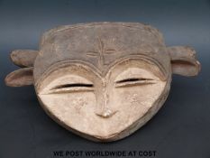 An African tribal mask in the form of two faces (length 17cm)