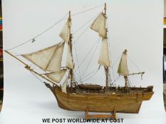 A scratch/kit built model of a three masted ship with cut out side section and visible interior,
