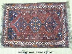 A Turkoman rug decorated with three guls on a wine ground (180 x 119cm)