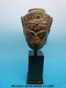 A post Khmer bronze buddha head with gilt remains to the face on mounted base