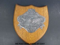A wooden mounted white metal embossed Northern Rhodesian police badge,