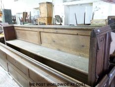 An oak church pew with linen fold end,