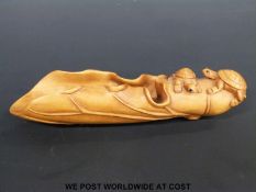 A cherry wood caddy spoon in the form of a folded leaf carved with two small tortoises