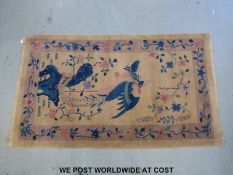A Chinese rug with bird decoration (210 x 122cm) and a Turkoman rug with wine ground (152 x 78cm)