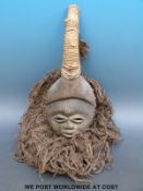 An African tribal Dan mask with raffia surround (length 42cm)