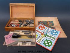 A boxed games compendium including carved wooden chess and draught pieces,