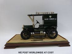 A tinplate model car in glass and mahogany display case
