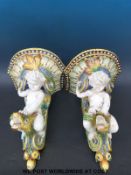 A pair of large majolica wall brackets in the form of putti riding a sea serpent,