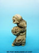 A Japanese Meiji period carved ivory netsuke of an elderly figure carrying a gourd (5cm tall)