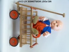 A child's wooden pull-a-long cart and Kader doll