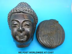 A lacquer carving of a Thai head opening to reveal a multiple armed deity to one side and a Thai