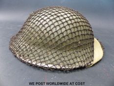 A WWII British Army helmet with camouflage net