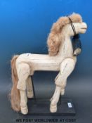 A carved wooden horse with articulated limbs,