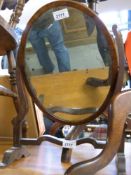 An Edwardian free standing oval mirror with banded inlay to the frame