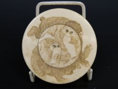 An ivory lidded pot carved with two monkeys (diameter 6.