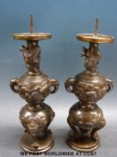 A pair of Japanese bronze candlesticks with decoration of dragons, foo dogs,
