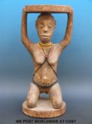 An African figural tribal stool with a kneeling female figure supporting the seat and bead