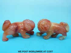 A pair of Chinese carnelian agate carvings in the form of foo dogs