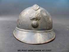 A French WWI military helmet with RB and flaming grenade to front, of four piece construction (comb,