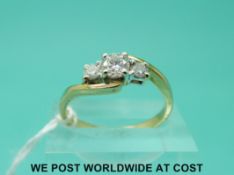 An 18ct gold ring set with three diamonds in a twist setting,