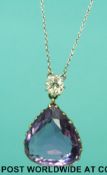A white metal necklace set with a pear cut amethyst below a old mine cut diamond of approximately 0.