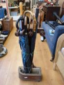 A mahogany stick stand with umbrellas
