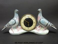 A c1980's Mercedes German mantel clock set in a ceramic pigeon figurine display by Jena Holland
