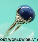 A white metal ring marked 14k set with a star sapphire and diamonds (size Q)