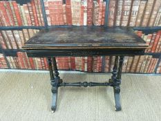 A 19thC ebonised fold over card table in the Shoolbred style,