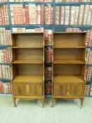 A pair of mahogany and burr wood waterfall backcase cabinets with shaped crossbanded borders and