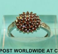 A 9ct white gold ring set with red diamonds and baguette cut diamonds to the shoulders (Size N, 2.