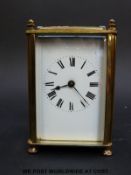 An early to mid 20thC brass carriage clock with white enamelled dial, Roman numerals,
