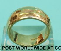 A 9ct gold wedding band with incised decoration (Size O, 9.
