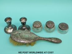 A quantity of hallmarked silver mounted items to include dwarf candlesticks, dressing table bottles,
