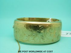 A 9ct gold cuff bangle with engraved decoration of flowers and foliage (30.