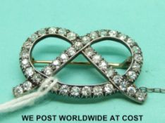 A yellow metal brooch in the form of a bow set with diamonds