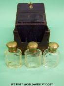 A leather cased set of three hallmarked silver topped scent bottles by Cross of London,