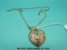 A 9ct gold embossed heart pendant depicting cherubs on a 9ct gold chain (18.