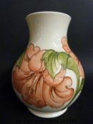 A large Moorcroft vase in Hibiscus pattern on a cream ground (24cm tall)