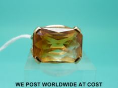 A yellow metal ring set with a cushion cut citrine,